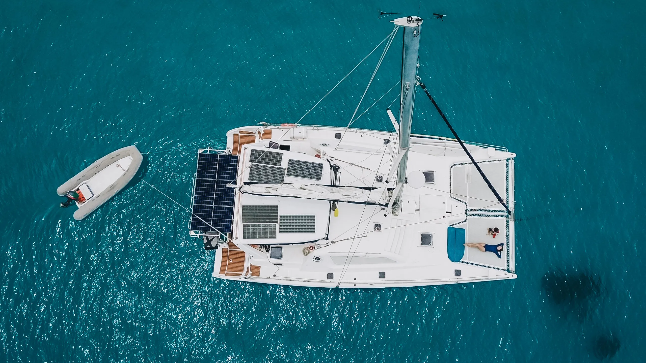 Aerial view of a catamaran and dinghy