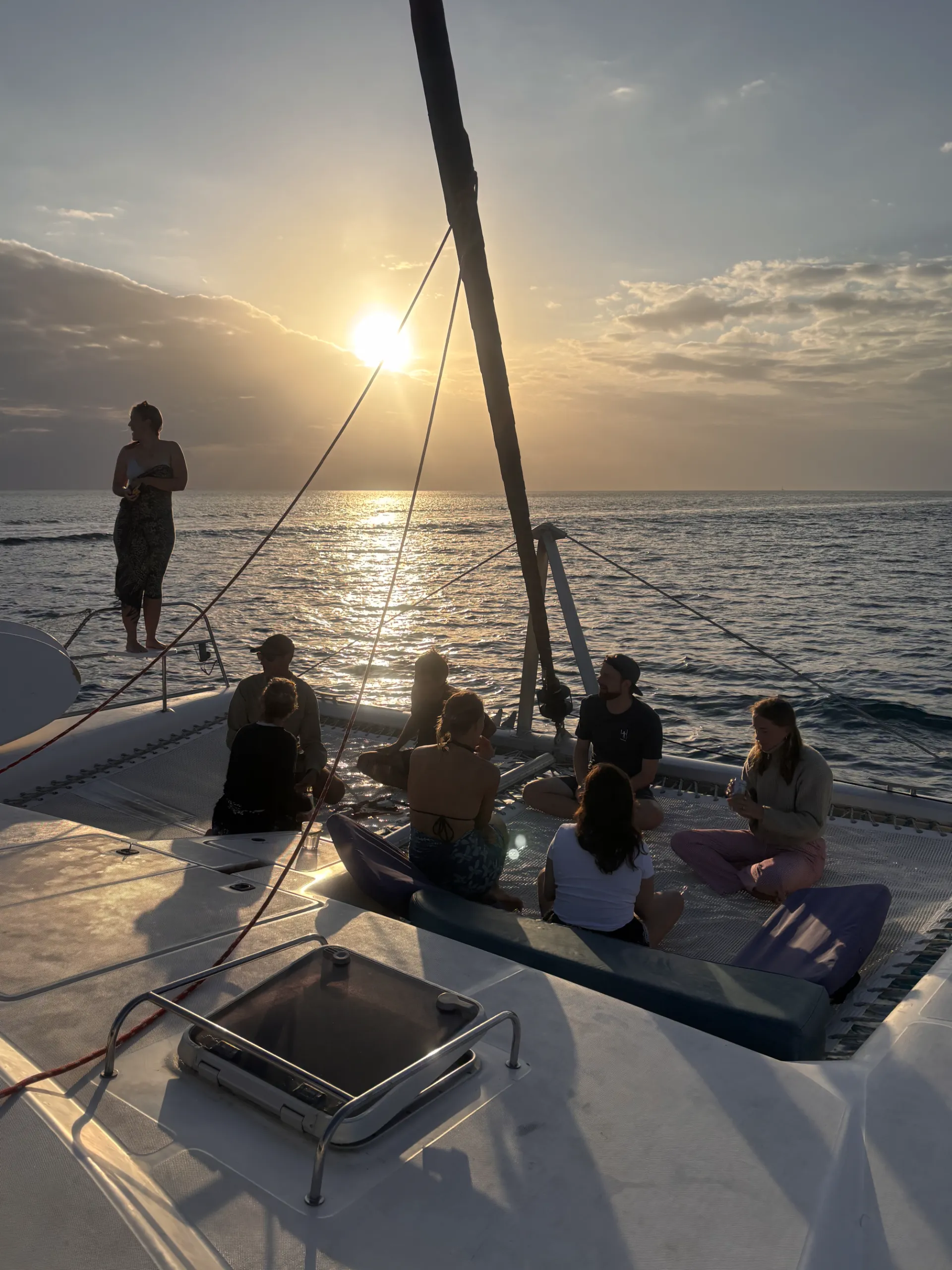 Guests relaxing on a catamaran deck at sunset