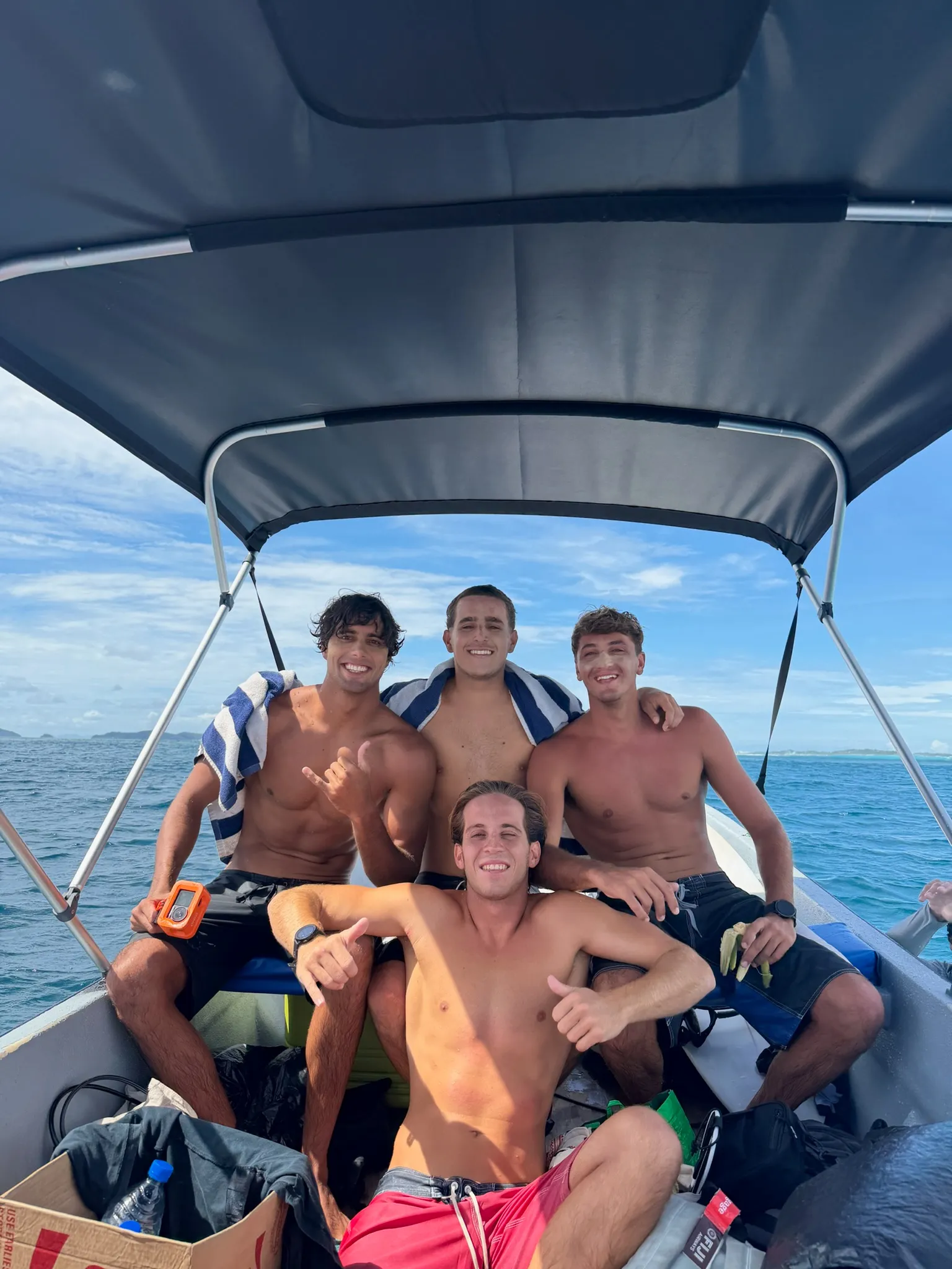 Guests together aboard a shaded boat