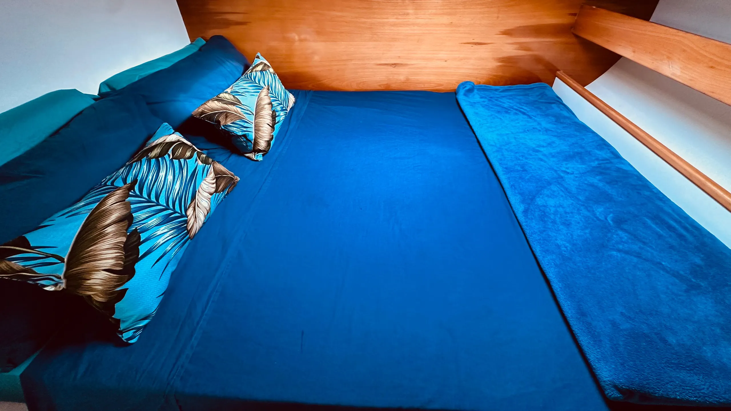 Yacht cabin with blue bedding and patterned cushions